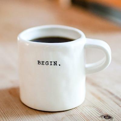 Taza de café con la palabra -begin- impresa.